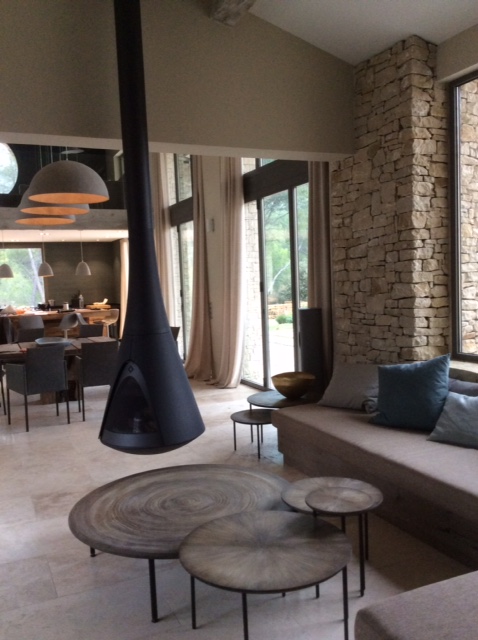 Coin feu où se mêlent la pierre, le verre et le bois